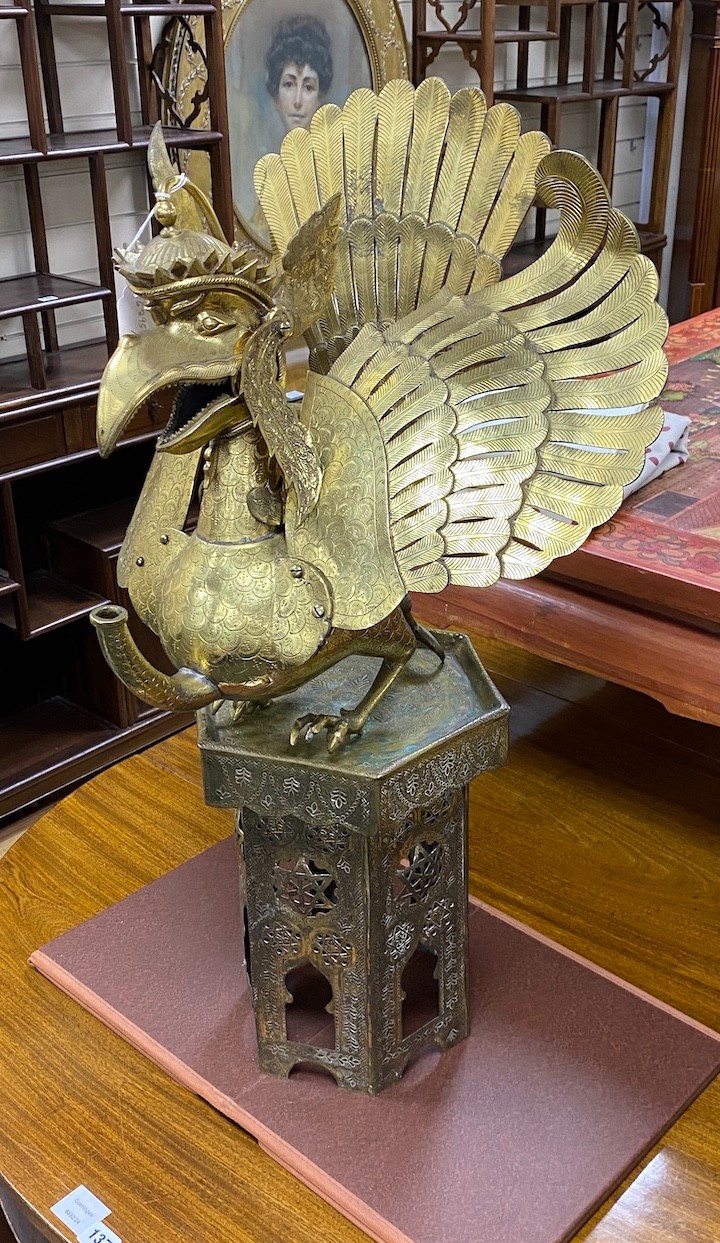 A large Indonesian brass Garuda figural oil lamp and a Islamic brass stand, 82cm tall